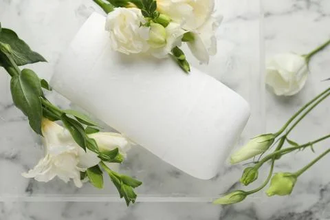 Solid deodorant and beautiful eustoma flowers on white marble table, top view 스톡 사진