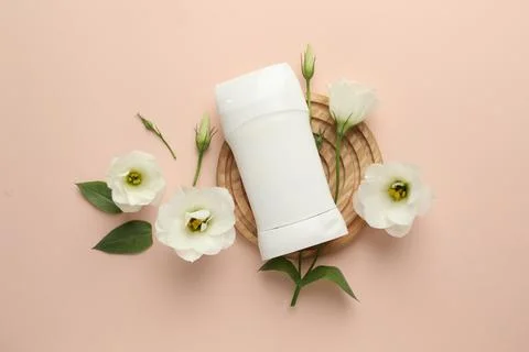 Solid deodorant and beautiful eustoma flowers on beige background, flat lay 스톡 사진