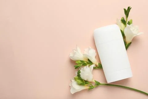 Solid deodorant and beautiful eustoma flowers on beige background, flat lay.. 스톡 사진