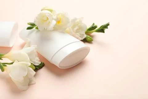 Solid deodorant and beautiful eustoma flowers on beige background, closeup 스톡 사진