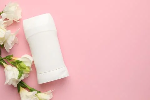 Solid deodorant and beautiful eustoma flowers on pink background, flat lay... 库存照片