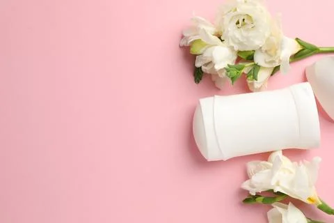 Solid deodorant and beautiful eustoma flowers on pink background, flat lay... 스톡 사진