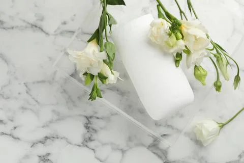 Solid deodorant and beautiful eustoma flowers on white marble table, top view 스톡 사진
