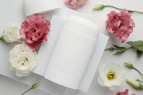 Solid deodorant and beautiful eustoma flowers on white background, top view Stock Photos