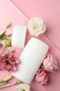 Solid deodorant and beautiful eustoma flowers on pink background, top view Stock Photos