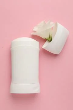 Solid deodorant and beautiful eustoma flower on pink background, top view Stock Photos