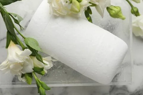 Solid deodorant and beautiful eustoma flowers on white marble table, top view Stock Photos