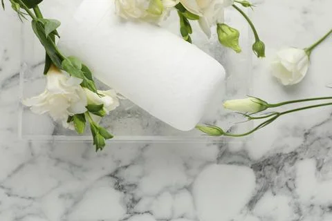 Solid deodorant and beautiful eustoma flowers on white marble table, top view Stock Photos