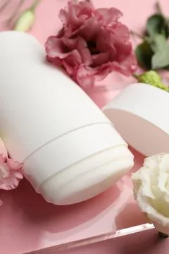 Solid deodorant and beautiful eustoma flowers on pink background, closeup Stock Photos