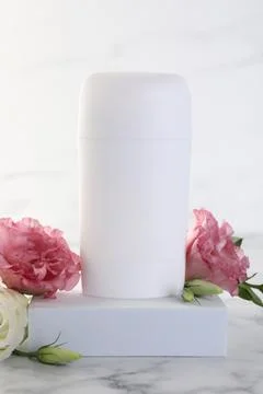 Solid deodorant and beautiful eustoma flowers on white marble table Stock Photos