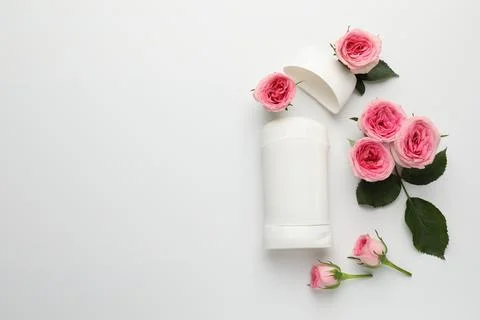 Solid deodorant and beautiful rose flowers on white background, flat lay. S.. 스톡 사진