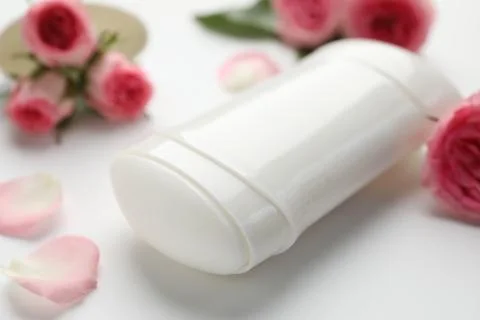 Solid deodorant and beautiful rose flowers on white background, closeup 스톡 사진