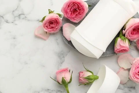 Solid deodorant and beautiful rose flowers on white marble table, flat lay... 스톡 사진