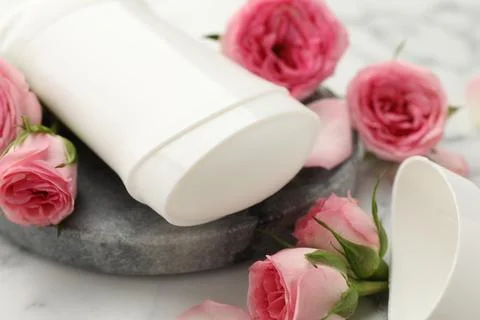 Solid deodorant and beautiful rose flowers on table, closeup Stock Photos