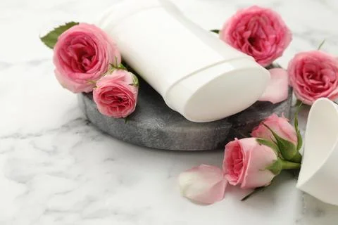 Solid deodorant and beautiful rose flowers on white marble table 스톡 사진