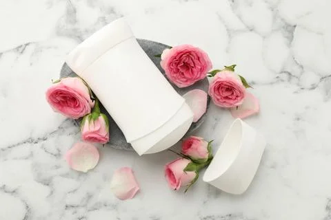 Solid deodorant and beautiful rose flowers on white marble table, flat lay 스톡 사진