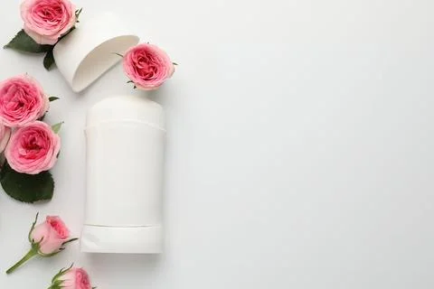 Solid deodorant and beautiful rose flowers on white background, flat lay. S.. Stock Photos