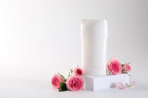 Solid deodorant and beautiful rose flowers on white background, space for tex Stock Photos