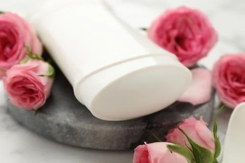 Solid deodorant and beautiful rose flowers on table, closeup Stock Photos