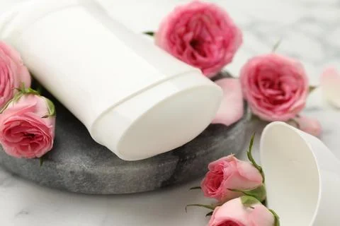 Solid deodorant and beautiful rose flowers on table, closeup Stock Photos