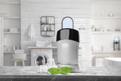 Solid deodorant, mint and ice cubes on grey table in bathroom. Mockup for des Stock Photos