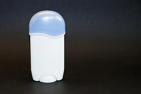 Solid deodorant in white packaging on black background close-up Stock Photos