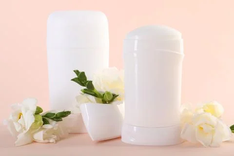Solid deodorants and beautiful eustoma flowers on beige background Stock Photos