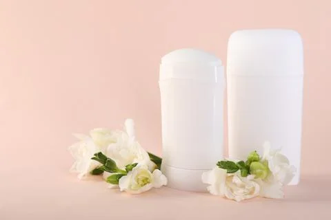 Solid deodorants and beautiful eustoma flowers on beige background 库存照片