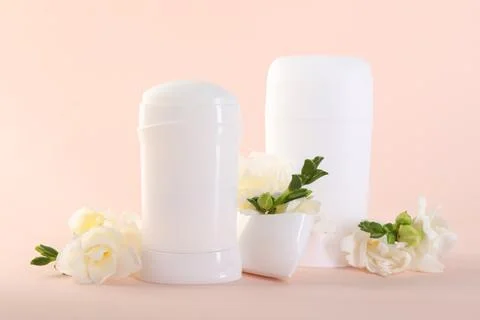 Solid deodorants and beautiful eustoma flowers on beige background Stock Photos