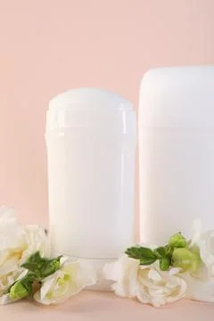Solid deodorants and beautiful eustoma flowers on beige background Stock Photos