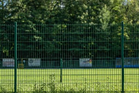 Solid green metal wire fence supported by strong posts Stockfoto's