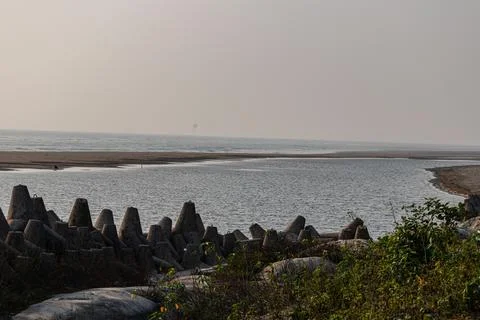 Solid grey coastal defenses securing fragile shoreline with vast ocean view Foto stock