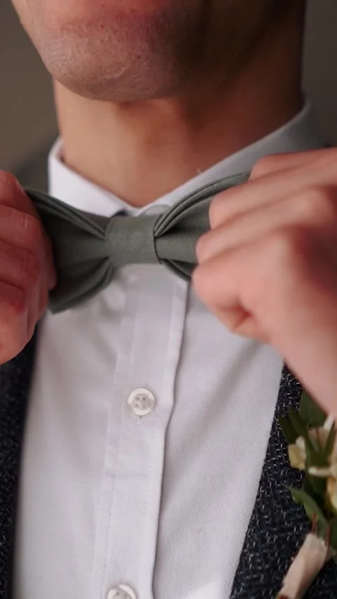 Solid handsome man groom in a business suit jacket straightens his tie in the Stock Footage 252268091