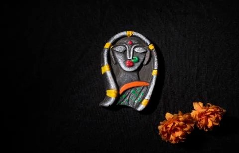 Solid made idol of a female hindu goddess Durga with dry flowers in black cop Stock Photos