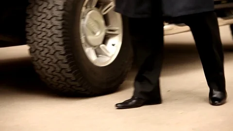 A solid man comes out of an expensive black car Stock Footage 77076456