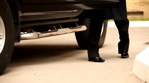 A solid man comes out of an expensive black car Stock Footage 77076563