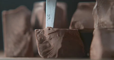 Solid milk chocolate being sliced with knife closeup ultra slow motion with 4k P Video stock 199461564