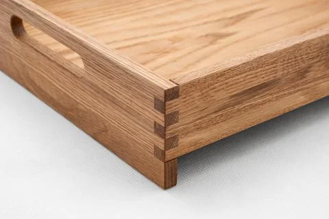Solid oak wood tray with dovetail joints and cutout handles closeup Stock Photos