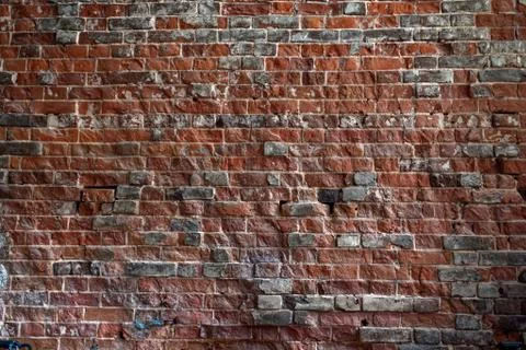 Solid red brick wall with rough old masonry. Abstract background for design 写真素材