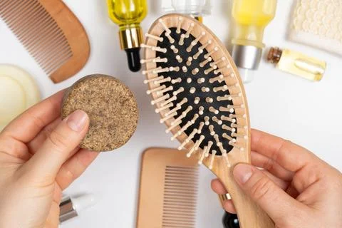 Solid shampoo and wooden comb in the hands of a woman. Eco Hair Care Products. 스톡 사진
