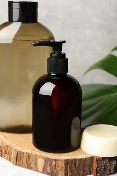 Solid shampoo bar and bottles of cosmetic product on white marble table, cl.. Stock Photos