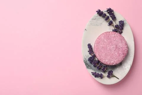 Solid shampoo bar and lavender flowers on pink background, top view. Space fo 写真素材