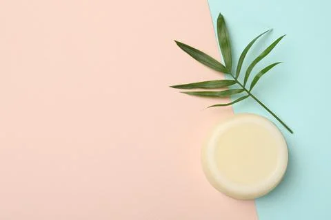 Solid shampoo bar and leaf on color background, top view. Space for text Stock Photos