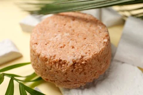 Solid shampoo bar and leaf on beige table, closeup. Hair care 写真素材