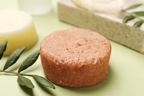 Solid shampoo bar and leaf on green background, closeup. Hair care 스톡 사진