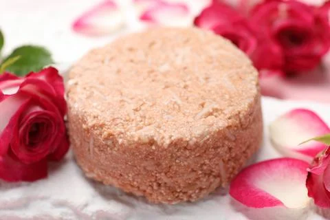 Solid shampoo bar and roses on table, closeup. Hair care Stock Photos