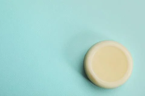 Solid shampoo bar on turquoise background, top view. Space for text Foto stock