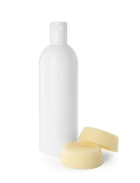 Solid shampoo bars and bottle of cosmetic product on white background Stockfoto's