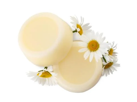 Solid shampoo bars and chamomiles on white background, top view. Hair care Foto stock