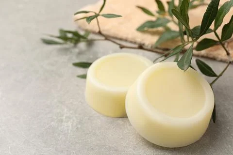 Solid shampoo bars and green twigs on grey table 写真素材